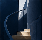 Light falling across a quiet navy staircase